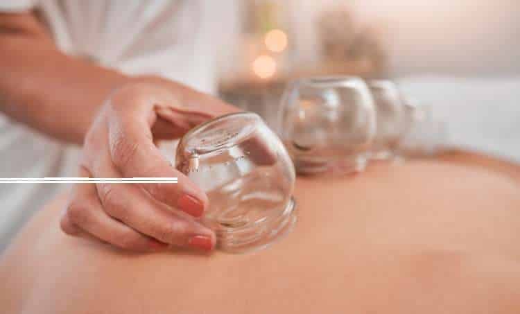 Glass cupping cup being placed on a person’s back