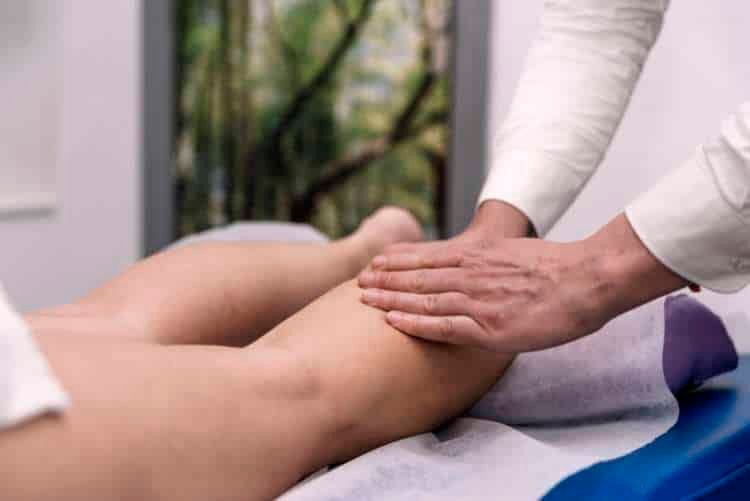 Therapist massaging a patient’s calf