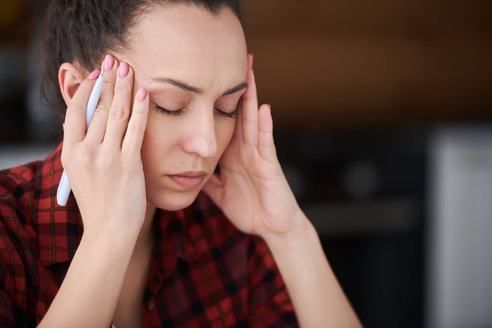 Woman holding her temples with her eyes closed