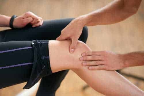 Person holding their knee after exercise