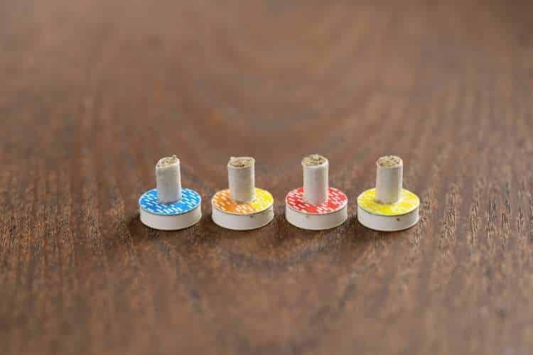 Four moxa cones on coloured stands on a wooden table